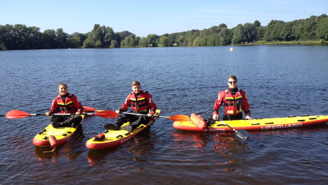 Lifeguards wearing dry suits with surf skis