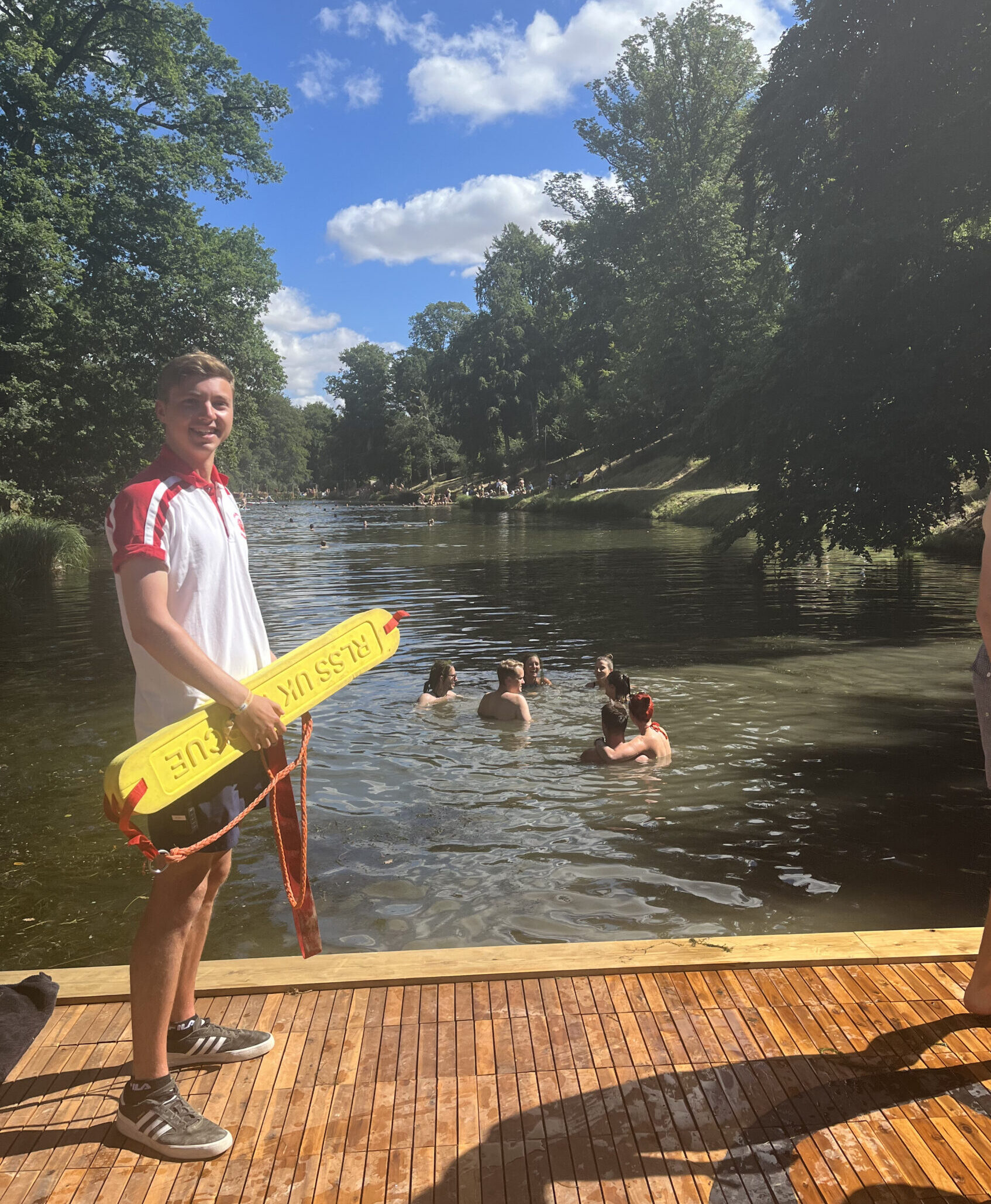 Lifeguard next to lake with swimmers