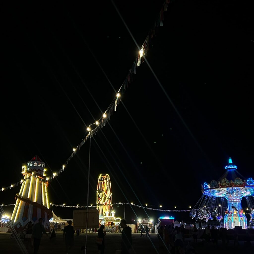 Funfair rides at nighttime at Wilderness festival