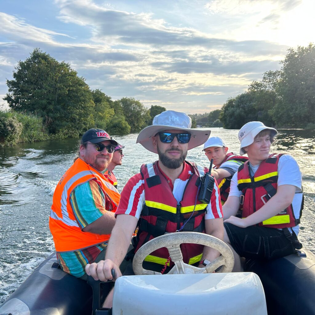 Lifeguards on safety boat travelling on River Thames at Reading festival
